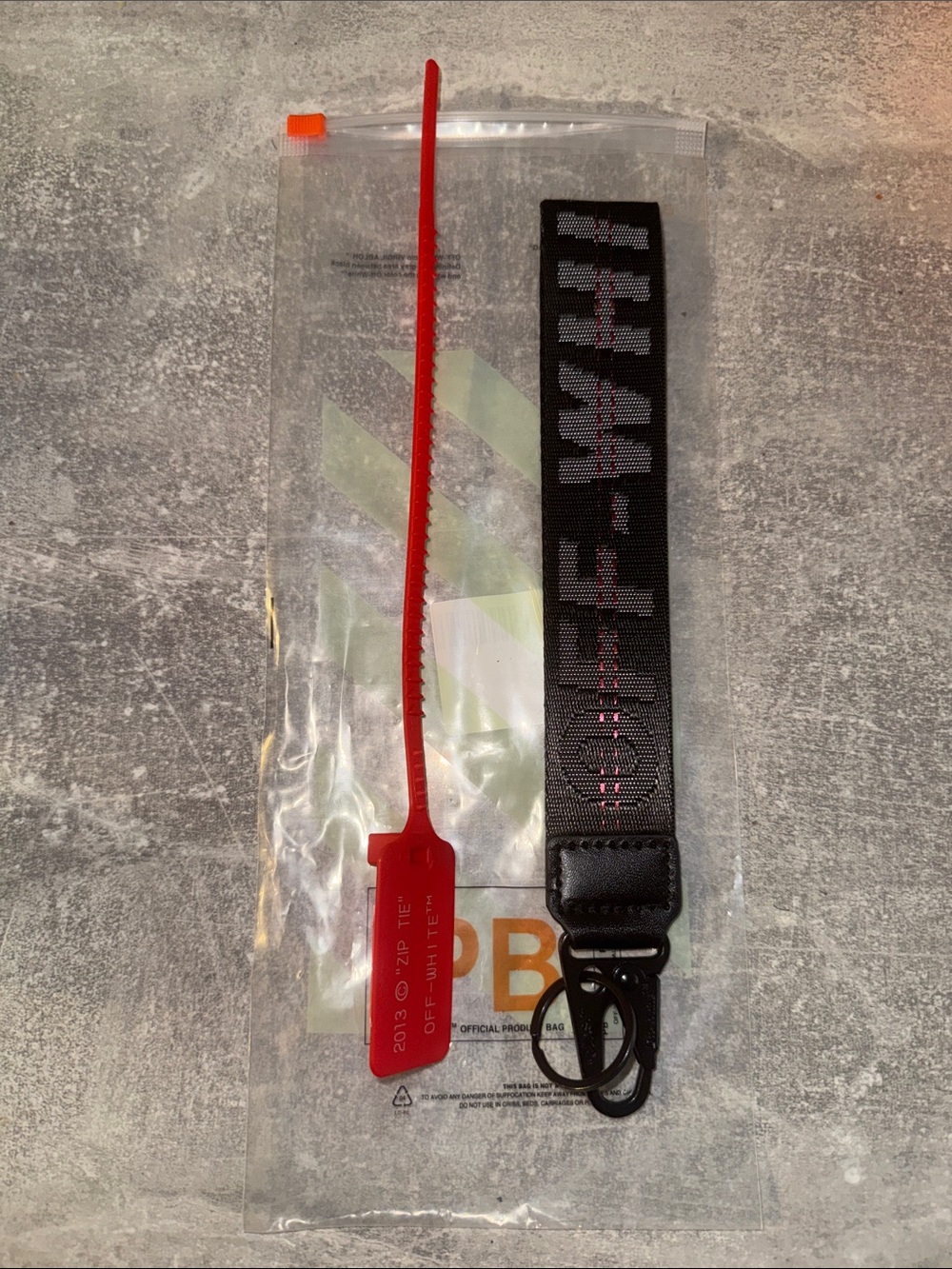 Off-White Black Key Strap with Red Zip-Tie Accent